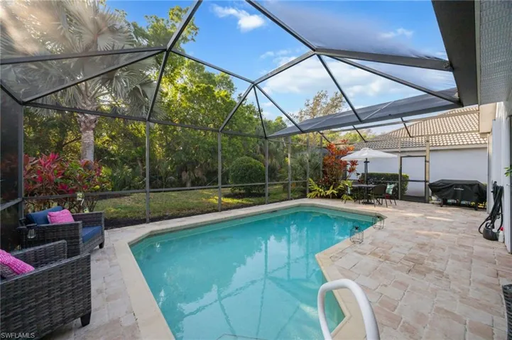Swimming pool featuring a sunroom, a patio, a lanai, outdoor dining area, and grilling area