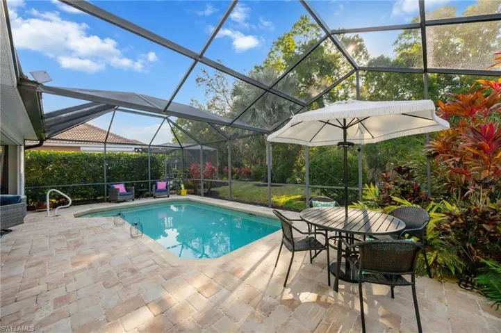 Swimming pool featuring a sunroom, a lanai, outdoor dining space, and a patio