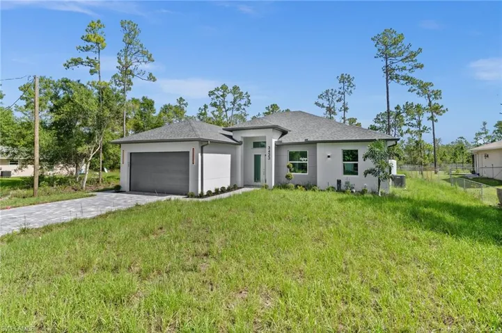 View of front of house featuring decorative driveway, a garage, a shingled roof, and stucco siding