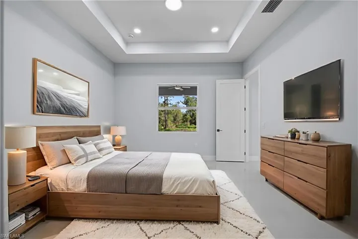 Bedroom with recessed lighting, a raised ceiling, and light tile patterned flooring