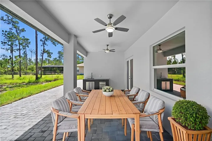 View of patio with outdoor dining space and ceiling fan