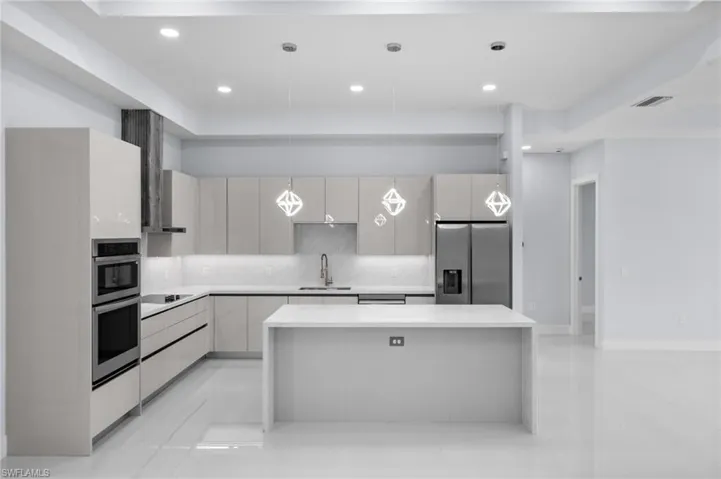 Kitchen featuring appliances with stainless steel finishes, modern cabinets, tasteful backsplash, recessed lighting, and light countertops