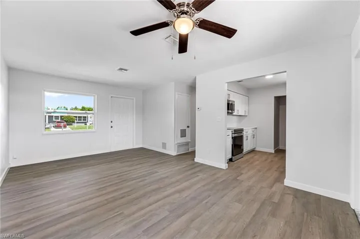 Unfurnished living room featuring ceiling fan and light hardwood / wood-style floors