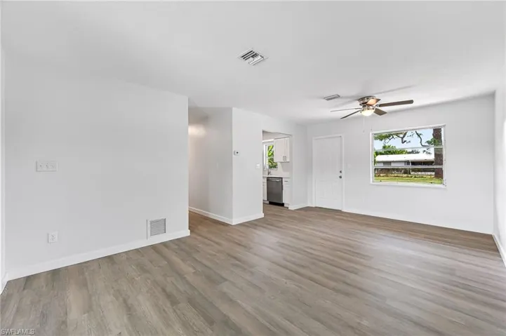 Unfurnished living room featuring ceiling fan and hardwood / wood-style floors