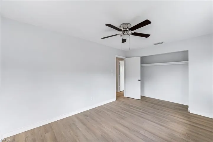 Unfurnished bedroom with hardwood / wood-style floors, a closet, and ceiling fan