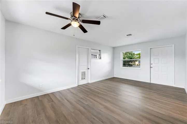 Unfurnished living room featuring ceiling fan and wood-type flooring