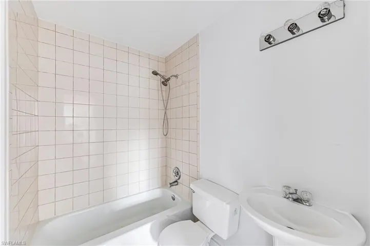 Full bathroom featuring sink, tiled shower / bath, and toilet