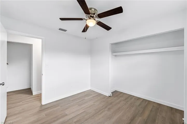 Unfurnished room featuring ceiling fan and wood-type flooring