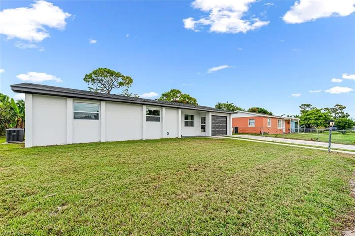 Single story home featuring central AC unit and a front lawn