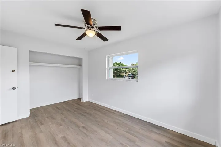Unfurnished bedroom featuring ceiling fan, a closet, and hardwood / wood-style floors