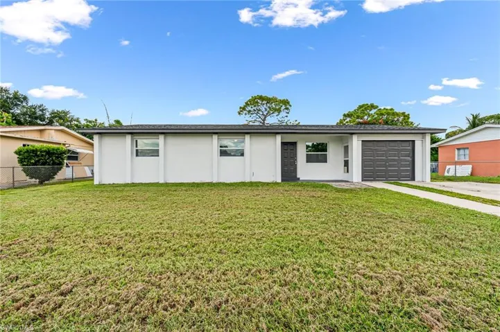 Single story home featuring a garage and a front lawn