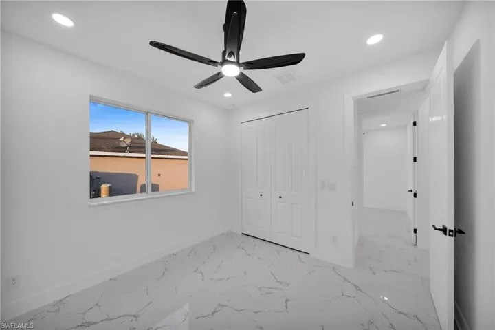 Unfurnished bedroom with light marble finish flooring, a ceiling fan, recessed lighting, and a closet