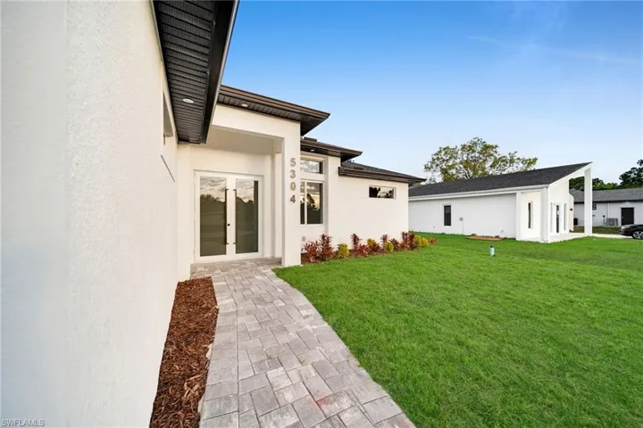 View of green lawn with french doors