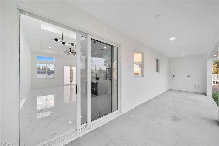 Doorway to property featuring a ceiling fan