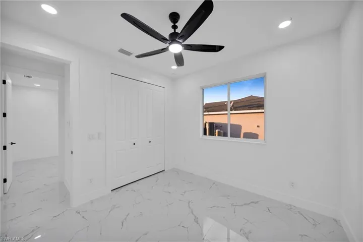Unfurnished bedroom with light marble finish floors, a closet, recessed lighting, and ceiling fan
