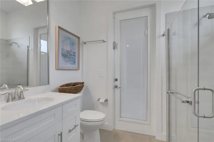 Modern bathroom with a white vanity featuring a rectangular sink, brushed nickel faucet, and white countertop