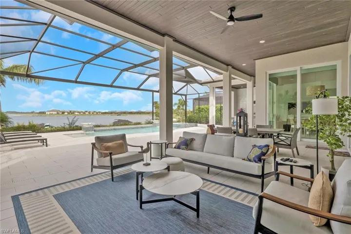 Expansive screened lanai featuring a wood-finish ceiling, ceiling fan, and large format tile flooring