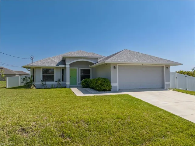Single story home featuring a garage and a front lawn