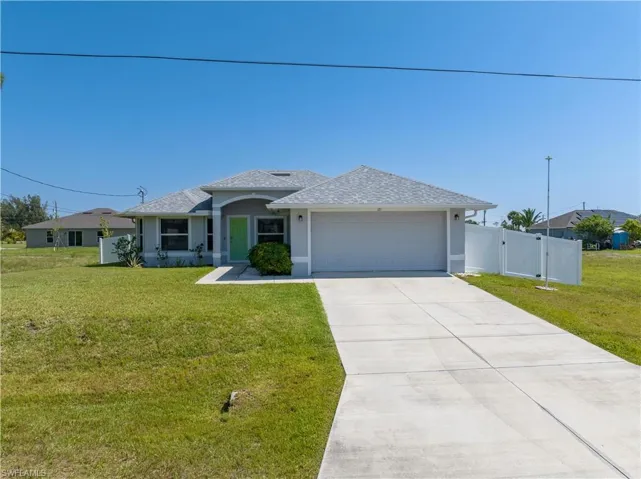 View of front of home with a garage and a front lawn