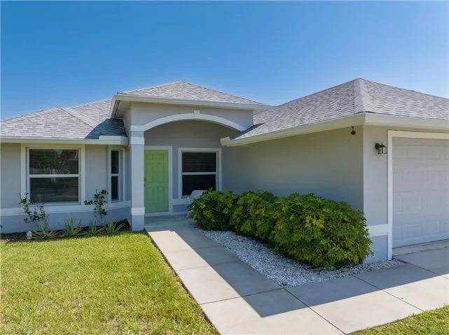 View of front of house with a garage and a front yard