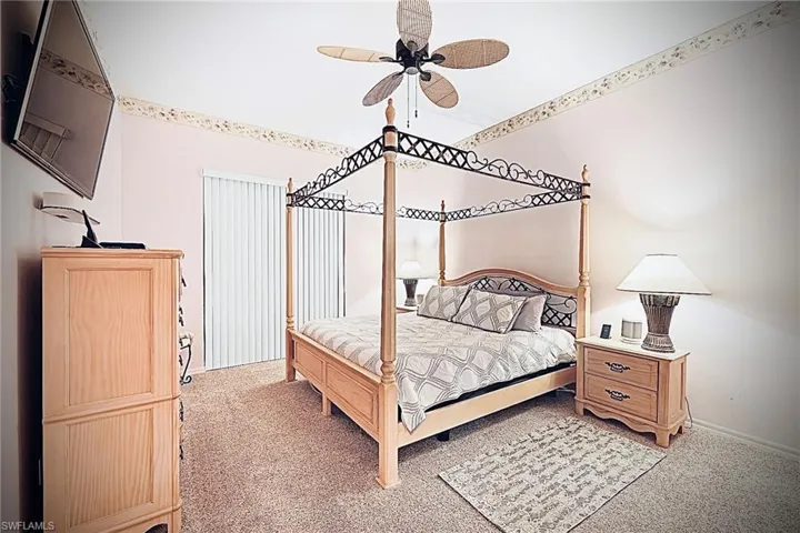 Primary bedroom with light carpet, ceiling fan