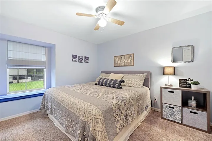 Carpeted bedroom featuring ceiling fan