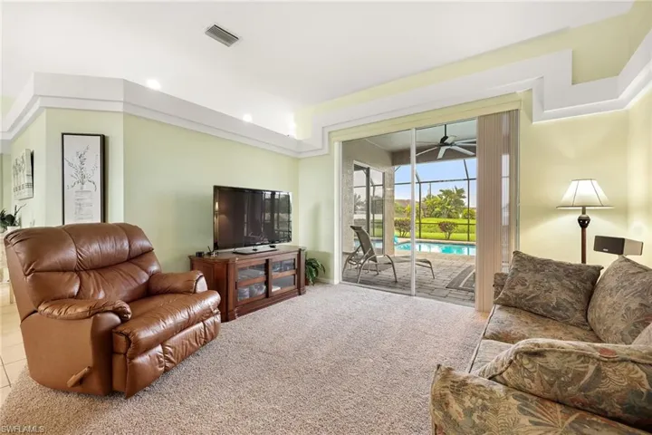 Carpeted living room featuring ceiling fan