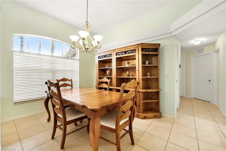 Dining room with light tile patterned floors and a chandelier