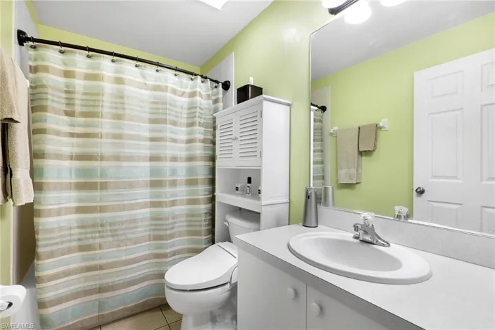 Bathroom featuring tile patterned floors, toilet, and vanity