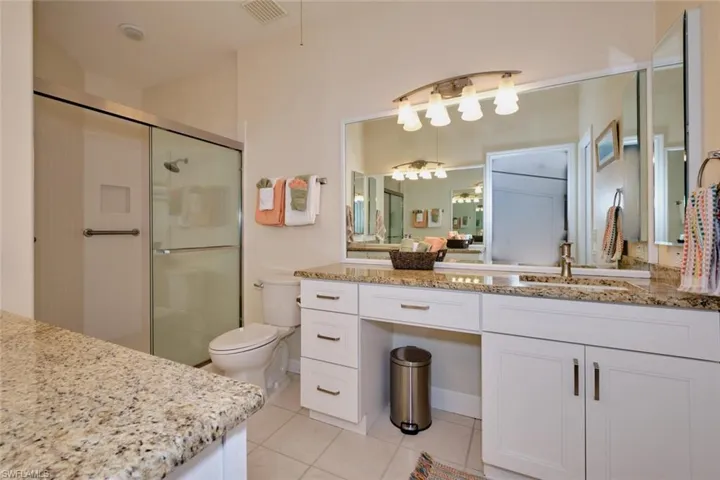Bathroom with vanity, a stall shower, and light tile patterned floors