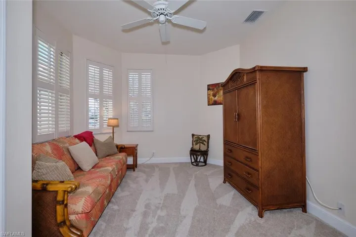 Sitting room featuring a ceiling fan and light carpet