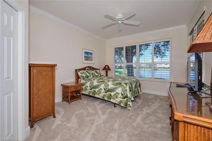 Bedroom with crown molding, light colored carpet, and a ceiling fan