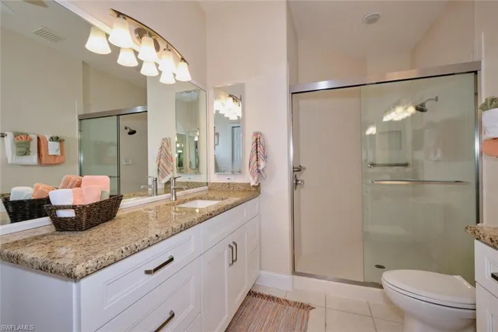 Full bath with vanity, a stall shower, and light tile patterned floors