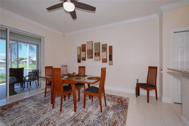 Dining space with ornamental molding, a ceiling fan, and light tile patterned floors