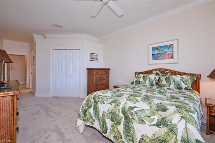 Bedroom featuring ornamental molding, carpet floors, a closet, and a ceiling fan