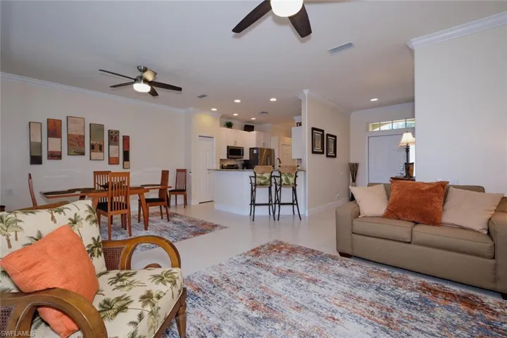 Living room featuring ceiling fan, ornamental molding, recessed lighting, and light tile patterned floors