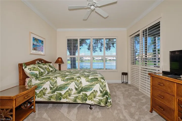 Bedroom featuring light colored carpet, a ceiling fan, and ornamental molding