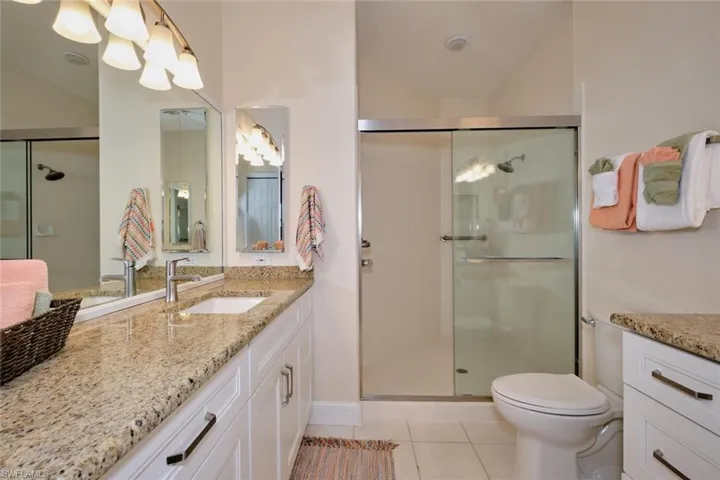 Full bathroom with vanity, a stall shower, and light tile patterned flooring