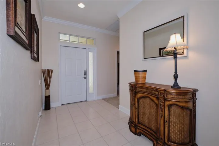 Entryway with crown molding, light tile patterned floors, and recessed lighting