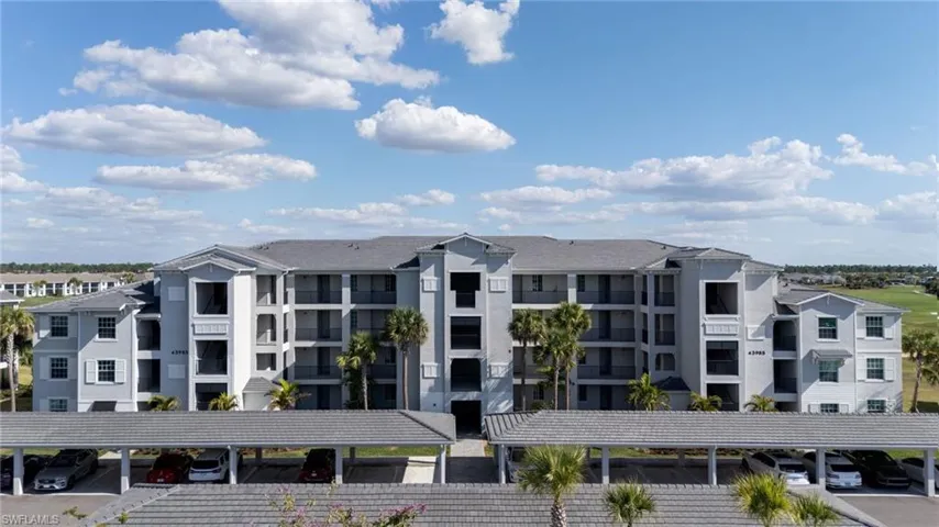 View of apartment building / complex with covered parking
