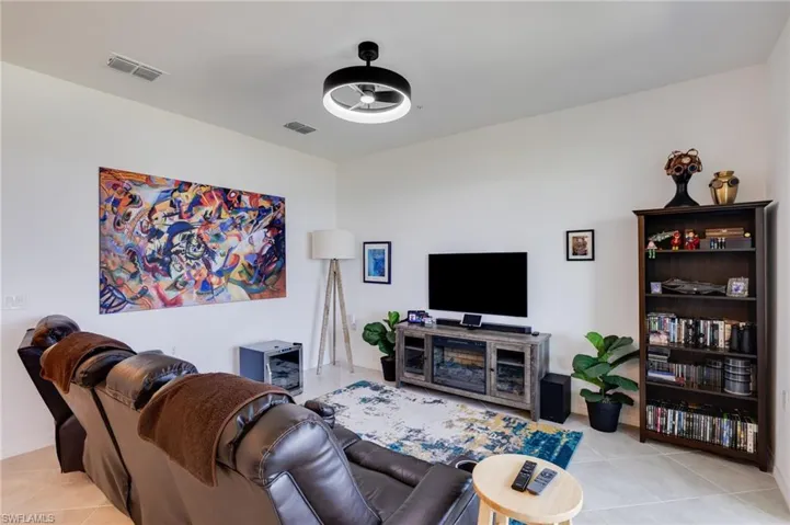 Living room with light tile patterned floors and a ceiling fan