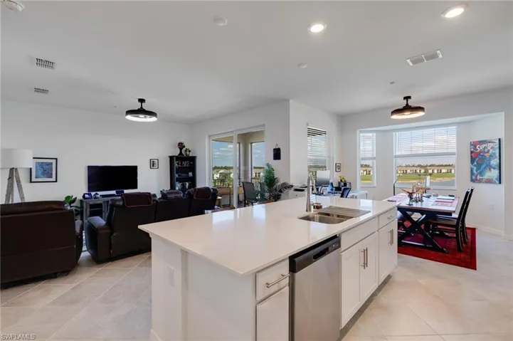 Kitchen featuring white cabinets, dishwasher, open floor plan, a center island with sink, and recessed lighting