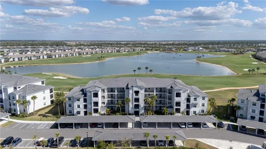 Aerial perspective of suburban area with a local golf course and a large body of water