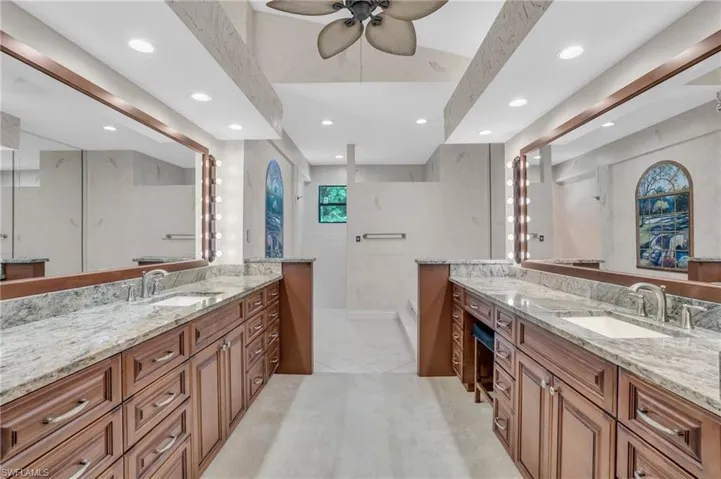 Spacious bathroom with dual vanities and ceiling fan