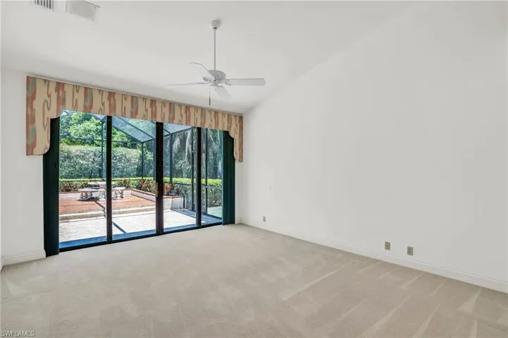 Owner's suite with ceiling fan and backyard views