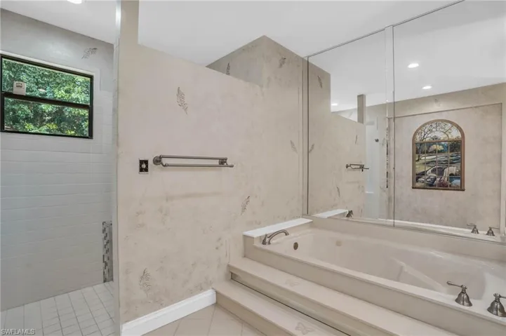 Bathroom featuring vanity, soaking tub, and walk-in shower