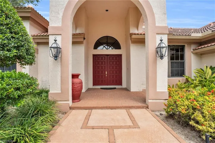 View of entrance featuring arched entryways and red door