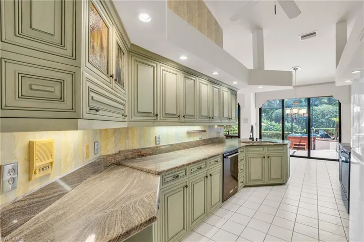Kitchen with custom cabinetry, granite countertops, and appliances