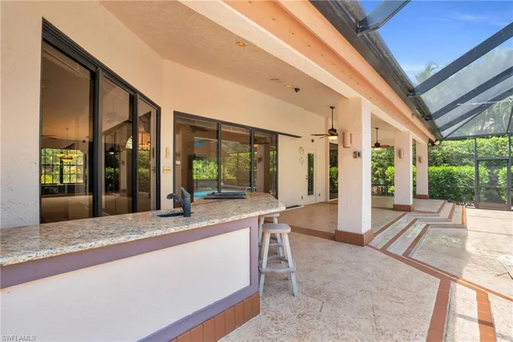 View of patio with a lanai, ceiling fan, and sink