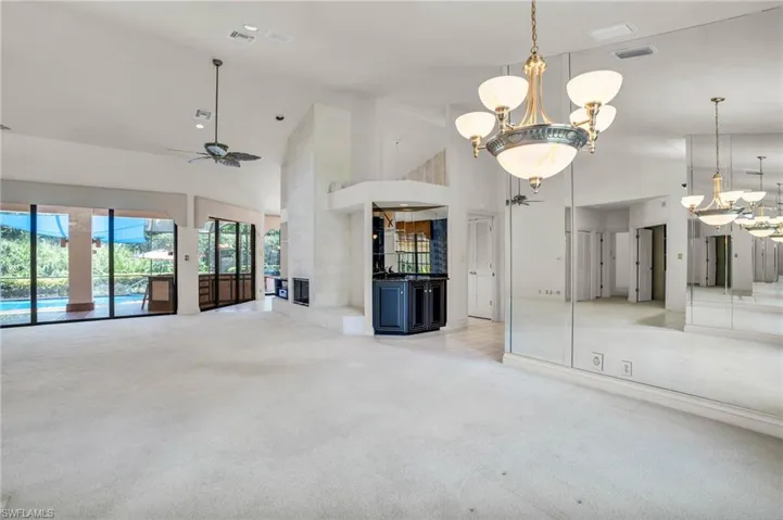 Bright living room with ceiling fans and chandelier